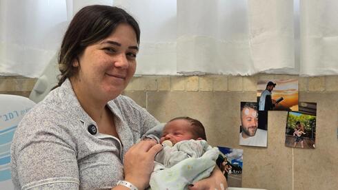 שובל קוסטנקו – צרפתי ובנה שנולד אתמול ברמב"ם. על הקיר, תמונותיו של אחיה, אופיר צרפתי ז"ל